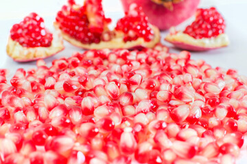 part of a pomegranate fruit with pomegranate seeds on white background