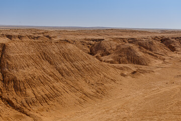 Valley of sandstone rocks on the horizon of the Sahara desert of Tunisia