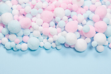 White, pink and blue soft pompons as a background.