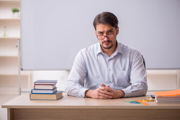 Young male teacher in front of whiteboard