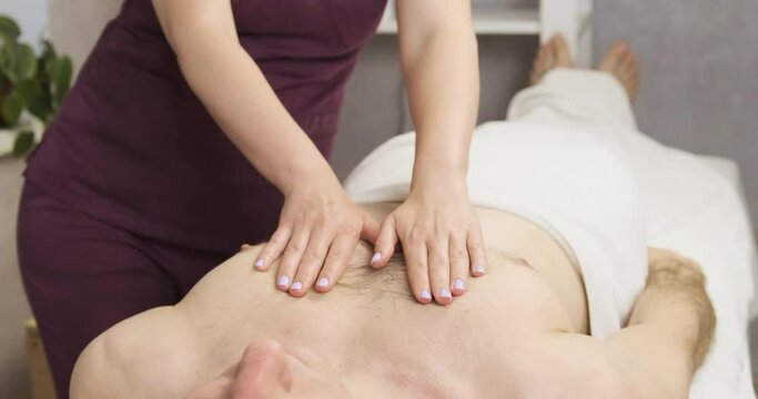Women's hands massage men's breasts. Professional massage in the spa. Relaxing chest massage