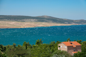 Fototapeta na wymiar AERIAL: Seafront vacation house overlooks the scenic Mediterranean landscape.