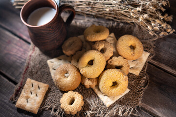 Fototapeta na wymiar Homemade cookies with a cup of milk on a rural wooden background