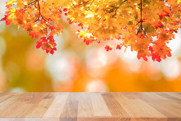 Naklejka na ściany i meble Wooden table top on shiny and leaves bokeh gold background. Can be used for display or montage your products. 