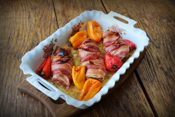 Dinner background. Grilled chicken breast wrapped in bacon in cooking pan on wooden rustic table . Top view