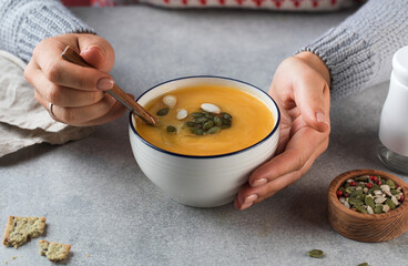 A bowl of warm pumpkin soup with seeds in your hands. Comfortable riding. Vegetarian dishes.