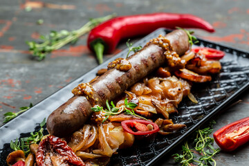 Roasted Potato and Sausage Dinner, cut into slices and fried in oil, served with chili peppers and mustard on a wooden background. Food recipe background. Close up