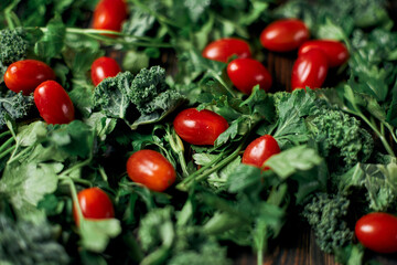 fresh tomatoes and sprigs of parsley on a wooden table.