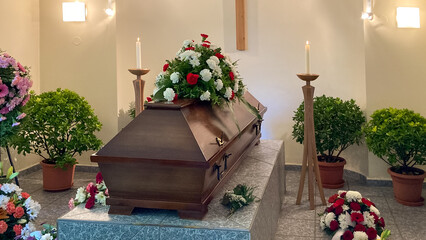 Casket prepared for funeral with flower bouquets