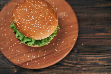 delicious burger on a wooden chopping board.