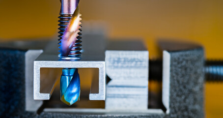 Steel tap and drill bit with blue purple nano titanium coating on a brown background. Two in one....