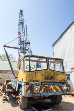 Vintage rusty crane vehicle. Old industrial truck with mounted crane