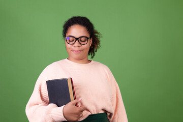 Beautiful african american woman on green background with notebooks student teacher wearing eye glasses happy smiling cheerful