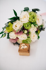 Wedding rings on the table near the wedding bouquet