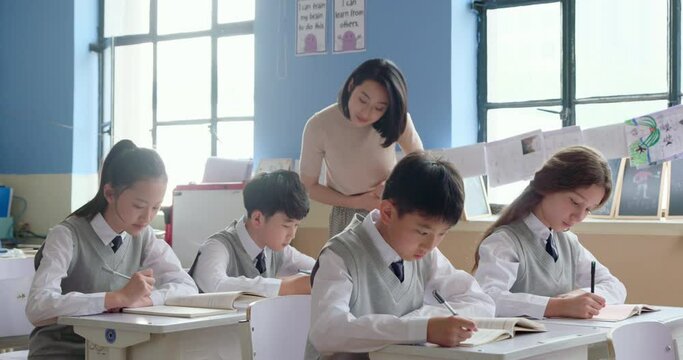 Young teacher helping students in classroom,4K - Powered by Adobe