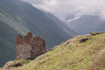 Ruins of medieval tower in Genaldon gorge on sunny summer day. Tmenikau village, North Ossetia, Russia.