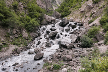 View of a waterfall in Gizeldon gorge on cloudy summer day. North Ossetia, Caucasus, Russia.