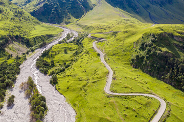 Drone view of road in Balkarsky Cherek valley on sunny summer day. Kabardino-Balkaria, Caucasus, Russia.
