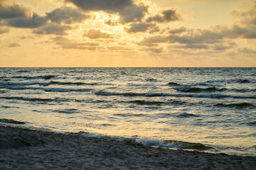 Fototapeta na wymiar Epic dark sunset sky above the sea shore after the storm. 