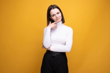 Close-up portrait of a surprised brunette on a yellow background