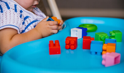 The child collects a multi-colored constructor. Children's classes in kindergarten or at home.
