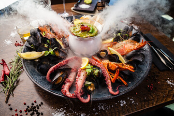 Seafood platter for 2-4 persons. Lobster, octopus, blue mussels, Argentina king prawns, tuna tartare. Delicious healthy traditional food closeup served for lunch in modern gourmet cuisine restaurant - 447876766