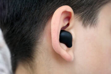 a child with a bluetooth headset in his ear listens to music,