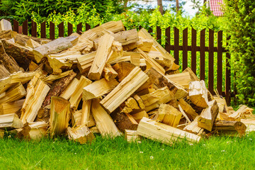 Stack of firewood on green grass.