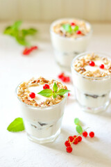 Dessert in a glass on a light background, decorated with nuts, mint leaves and berries. Creamy jelly. Parfait.