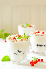 Dessert in a glass on a light background, decorated with nuts, mint leaves and berries. Creamy jelly. Parfait.