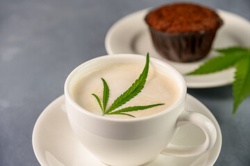 Hot Coffee drink with cannabis leaf on top of foam and cake or muffin