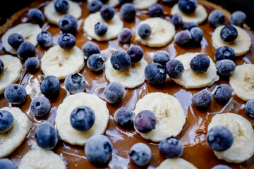 Caramel, banana, blueberry cake close-up