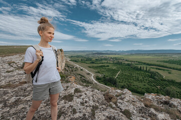 Girl hiking tourist on mountain with backpack.