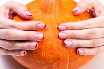 Female hands with a trendy autumn french manicure with red tips