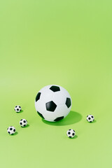 Soccer balls of different sizes on a green background. concept of football and sport. vertical