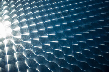 Metallic shiny surface made up of circles. It looks like fish scales.
