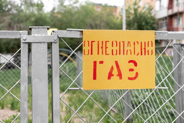 Fototapeta premium Yellow plate flammable gas on a metal fence