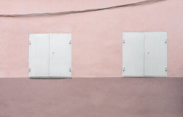 Pink wall with gray metal shutters