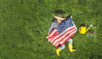 Man with the usa flag on lawn background. Top view. Holiday concept.
