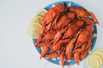 boiled crayfish served on a platter with herbs and lemon