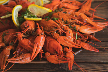boiled crayfish served on a platter with herbs and lemon