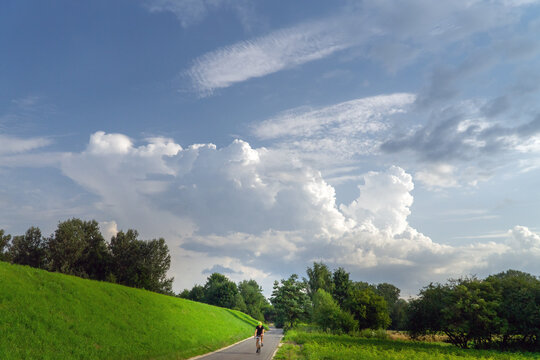 Rural landscape with a cyclist on the road © Andrzej Płotnikow