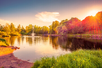 Pond with a fountain. Sunset. Woodland. Sand beach. Blue sky. Beautiful nature. Russia.