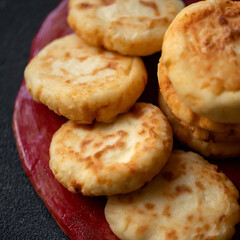 Close-up of Cottage cheese pancakes. Fresh fried cheese cakes on red Plate. Sweet breakfast. Top view. Soft focus.