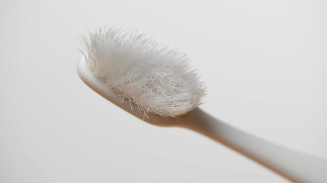Old toothbrush needs to be replaced. Used bristles in bad condition. Oral care. Close-up, isolated on white background.