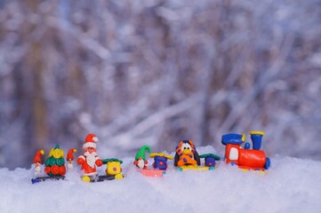Toy train with fairy-tale characters and gifts in the winter forest. Gnome, Santa Claus, penguin...