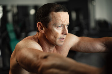 Naklejka na ściany i meble Portrait of a senior muscular man in a gym