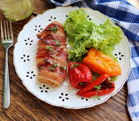 Dinner background. Grilled chicken breast wrapped in bacon in cooking pan on wooden rustic table . Top view