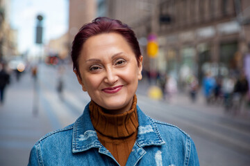 Portrait of a woman in the city. Older women headshot outdoors - 447897737