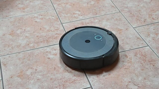 EL PASO, UNITED STATES - Jul 03, 2021: The robot Roomba cleaning and vacuuming a tile floor
